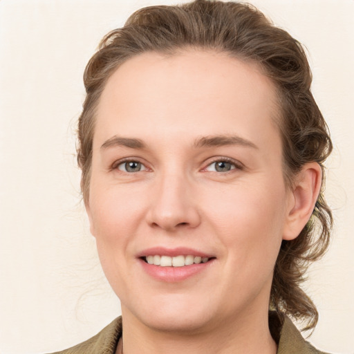 Joyful white young-adult female with medium  brown hair and blue eyes