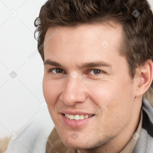 Joyful white young-adult male with short  brown hair and grey eyes