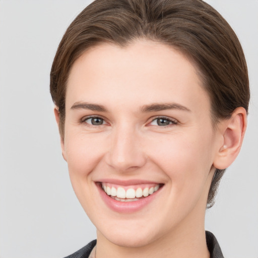 Joyful white young-adult female with short  brown hair and grey eyes