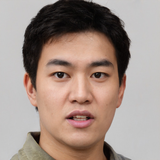 Joyful asian young-adult male with short  black hair and brown eyes