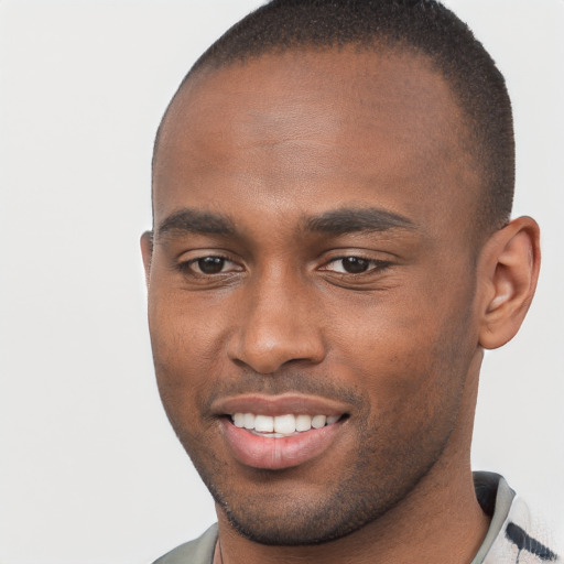 Joyful black young-adult male with short  brown hair and brown eyes