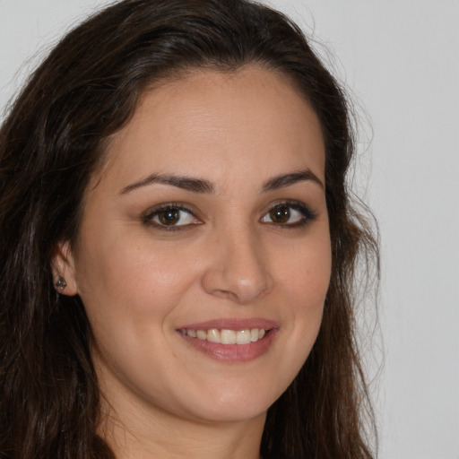 Joyful white young-adult female with long  brown hair and brown eyes