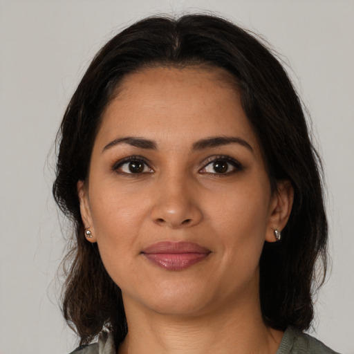 Joyful latino young-adult female with medium  brown hair and brown eyes