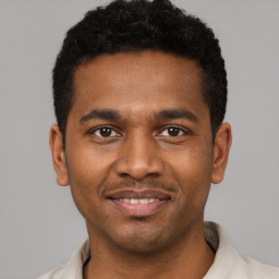 Joyful latino young-adult male with short  black hair and brown eyes