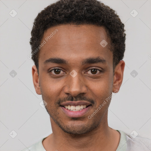 Joyful black young-adult male with short  black hair and brown eyes