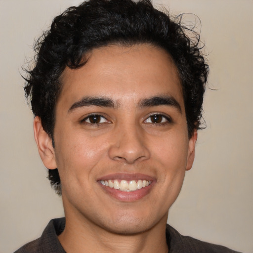 Joyful latino young-adult male with short  brown hair and brown eyes