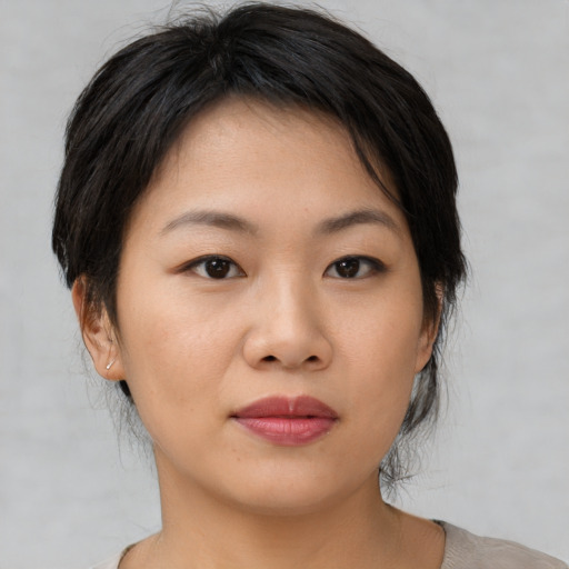 Joyful asian young-adult female with medium  brown hair and brown eyes