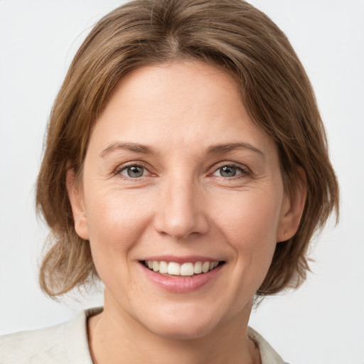 Joyful white adult female with medium  brown hair and grey eyes