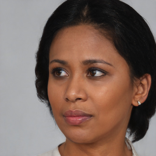 Joyful black young-adult female with medium  black hair and brown eyes