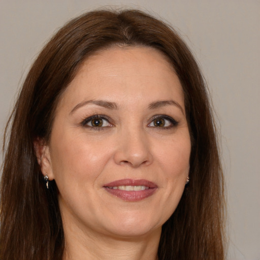 Joyful white adult female with long  brown hair and brown eyes