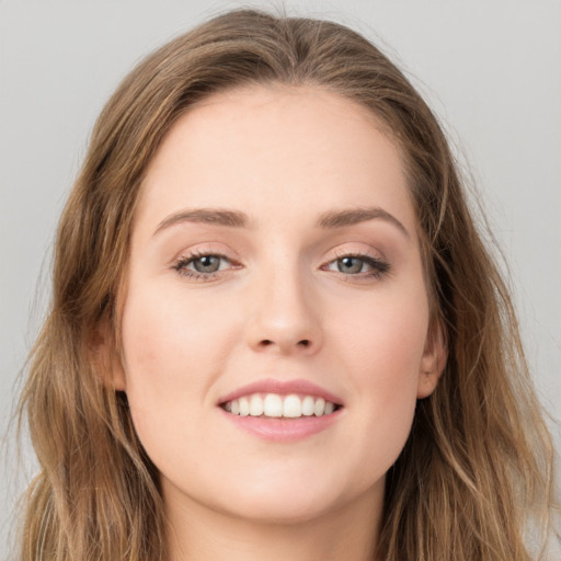 Joyful white young-adult female with long  brown hair and green eyes