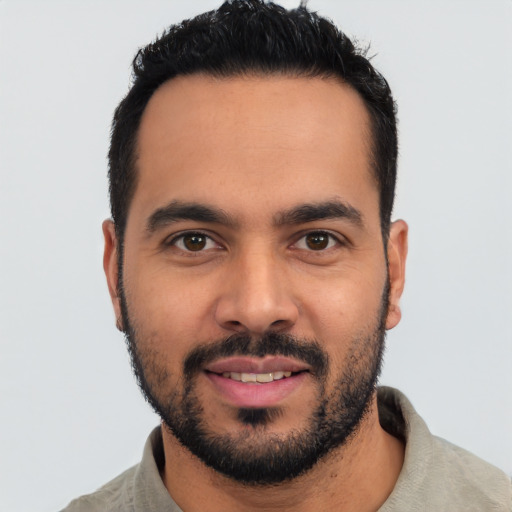 Joyful latino young-adult male with short  black hair and brown eyes