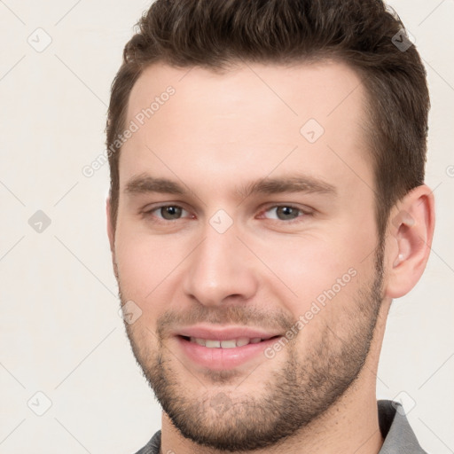 Joyful white young-adult male with short  brown hair and brown eyes