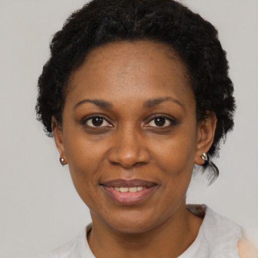 Joyful black adult female with short  black hair and brown eyes