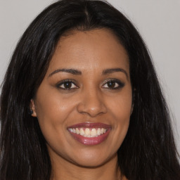 Joyful latino young-adult female with long  brown hair and brown eyes