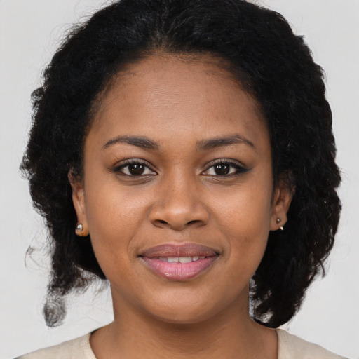 Joyful black young-adult female with medium  brown hair and brown eyes