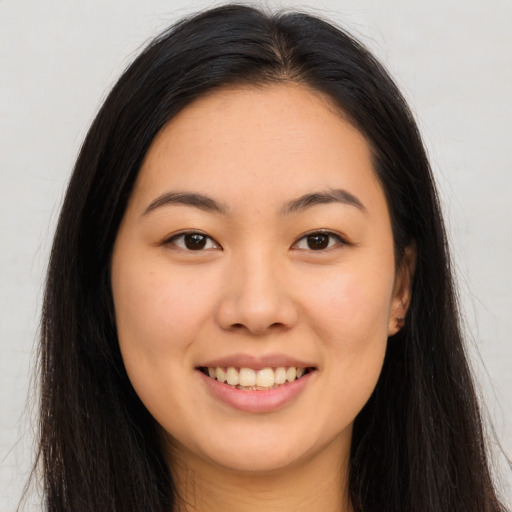Joyful asian young-adult female with long  brown hair and brown eyes