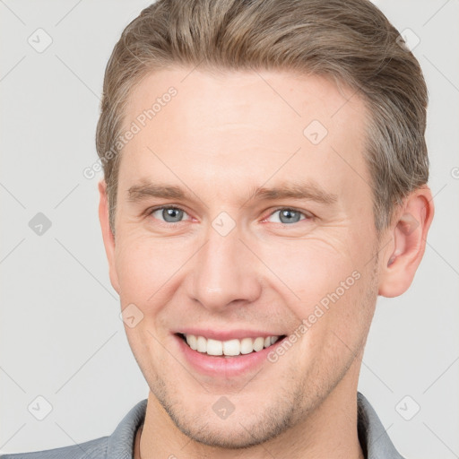 Joyful white adult male with short  brown hair and grey eyes