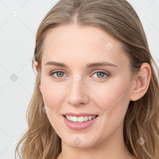 Joyful white young-adult female with long  brown hair and blue eyes