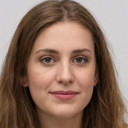 Joyful white young-adult female with long  brown hair and green eyes