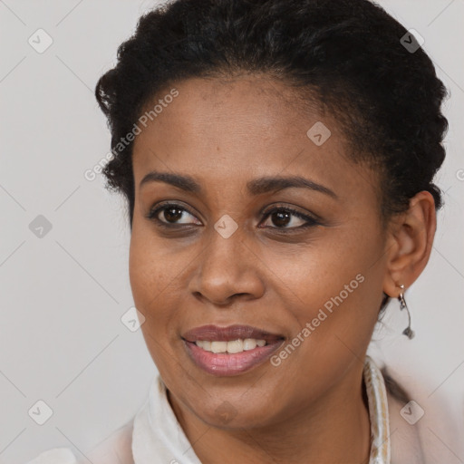 Joyful black young-adult female with short  brown hair and brown eyes