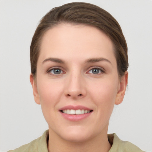 Joyful white young-adult female with short  brown hair and grey eyes