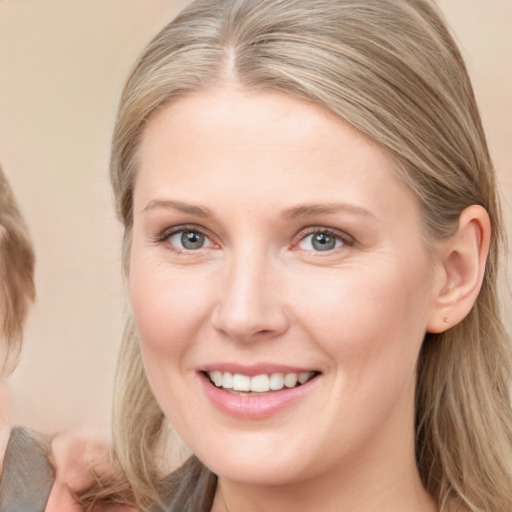 Joyful white young-adult female with medium  brown hair and blue eyes