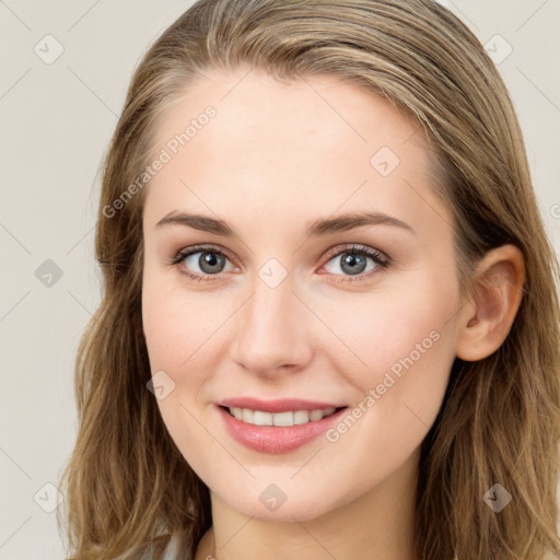 Joyful white young-adult female with long  brown hair and blue eyes