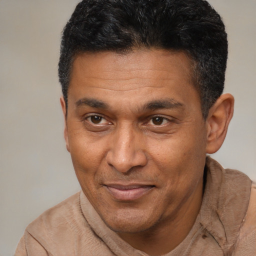 Joyful latino adult male with short  brown hair and brown eyes
