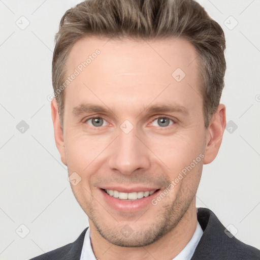 Joyful white young-adult male with short  brown hair and grey eyes