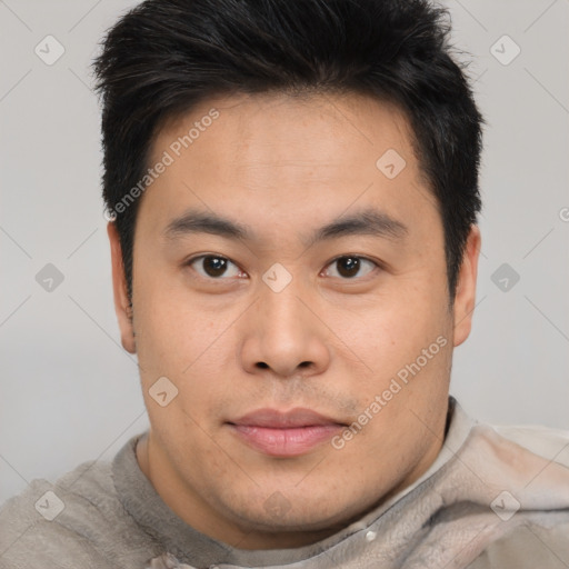 Joyful asian young-adult male with short  brown hair and brown eyes