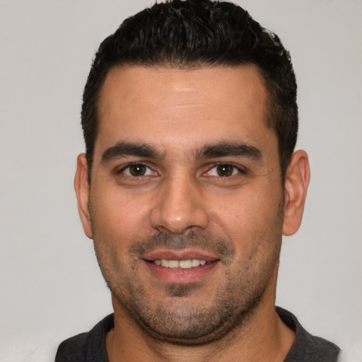 Joyful white young-adult male with short  black hair and brown eyes