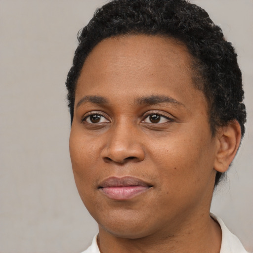 Joyful black young-adult female with short  brown hair and brown eyes