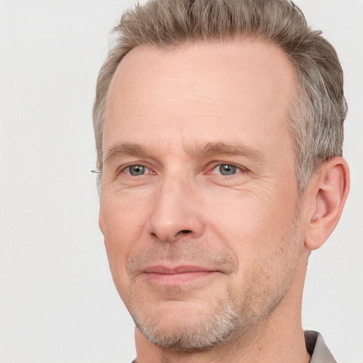 Joyful white adult male with short  brown hair and grey eyes