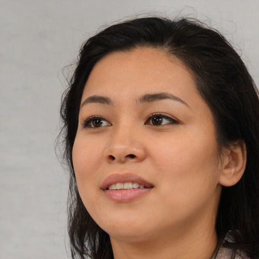Joyful asian young-adult female with long  brown hair and brown eyes
