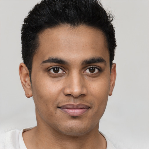 Joyful latino young-adult male with short  brown hair and brown eyes