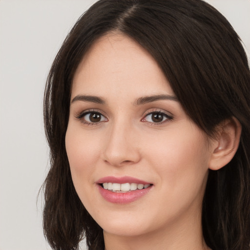 Joyful white young-adult female with long  brown hair and brown eyes