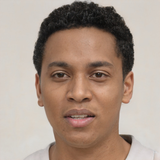 Joyful black young-adult male with short  black hair and brown eyes