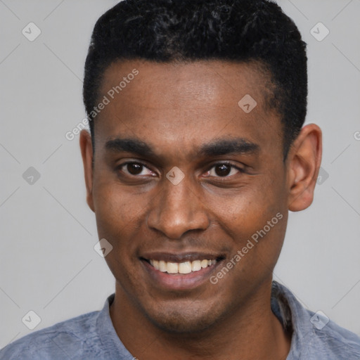 Joyful black young-adult male with short  black hair and brown eyes