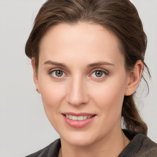 Joyful white young-adult female with medium  brown hair and grey eyes