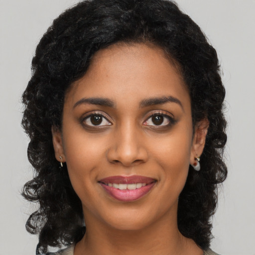 Joyful black young-adult female with long  black hair and brown eyes