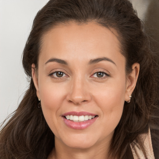 Joyful white young-adult female with long  brown hair and brown eyes