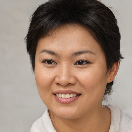 Joyful asian young-adult female with short  brown hair and brown eyes