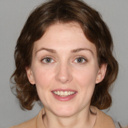 Joyful white young-adult female with medium  brown hair and green eyes