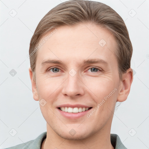 Joyful white young-adult male with short  brown hair and grey eyes