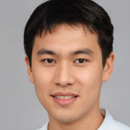Joyful asian young-adult male with short  brown hair and brown eyes