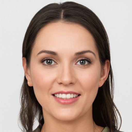 Joyful white young-adult female with long  brown hair and grey eyes