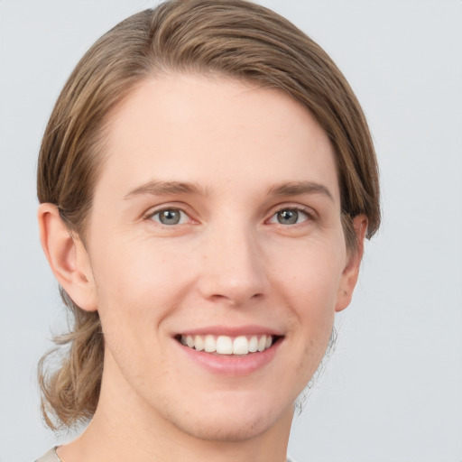 Joyful white young-adult female with medium  brown hair and grey eyes