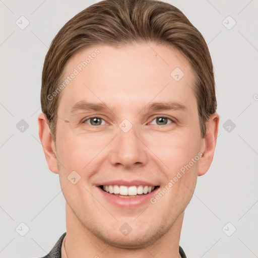 Joyful white young-adult male with short  brown hair and grey eyes