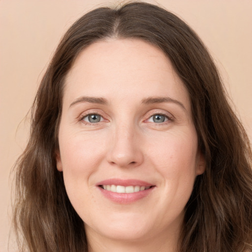 Joyful white young-adult female with long  brown hair and grey eyes